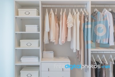 Clothes Hanging On Rail In White Wardrobe Stock Photo