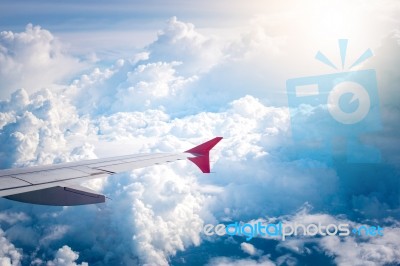 Cloudy Sky And Red Airplane Wing As Seen Through Window On Aircr… Stock Photo