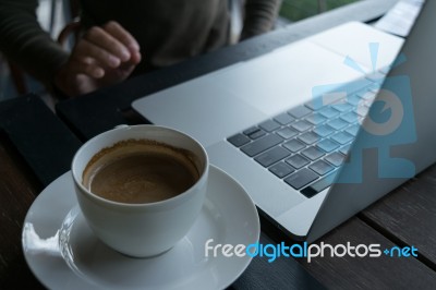 Coffee And Blur Laptop On Table Wood Background In Cafe Stock Photo