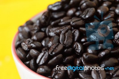 Coffee Bean In Coffee Cup With Yellow Background Stock Photo