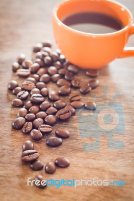 Coffee Beans With Coffee Cup On Wooden Table Stock Photo