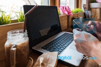 Coffee Cup  On A Table With Laptob And Graph Finance Diagram In Stock Photo