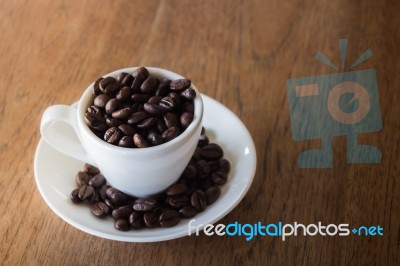 Coffee Cup Or Coffee Beans On Wooden Table Stock Photo