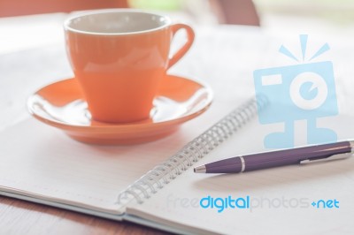 Coffee Cup, Pen And Notebook On Wooden Table Stock Photo