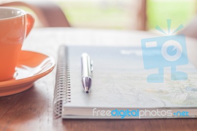 Coffee Cup With Pen And Spiral Notebook Stock Photo