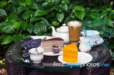 Coffee, Tea, Chocolate Crape Cake And Orange Cake On Table Stock Photo