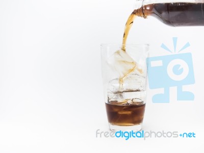 Cola Pouring From A Plastic Bottle Into A Glass Filled With Ice Cubes Stock Photo