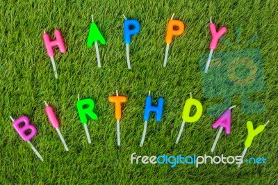 Colorful Happy Birthday Candles On Field Stock Photo