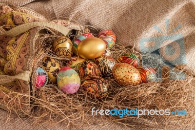 Colorful Painted Easter Egg And Fabric Bag On Hay Stock Photo