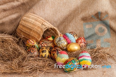 Colorful Painted Easter Egg In Wicker Basket On Hay Stock Photo