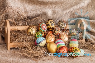 Colorful Painted Easter Egg On Hay In Wooden Shelf Stock Photo