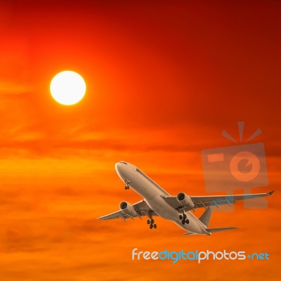 Commercial Airplane Flying With Sunset Background Stock Photo