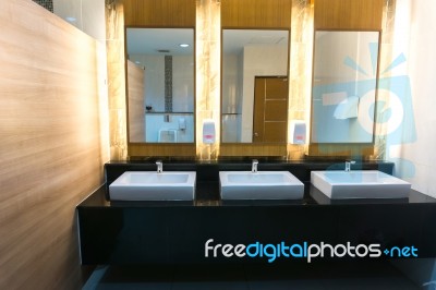 Commercial Bathroom With Three Sink And Mirror Stock Photo