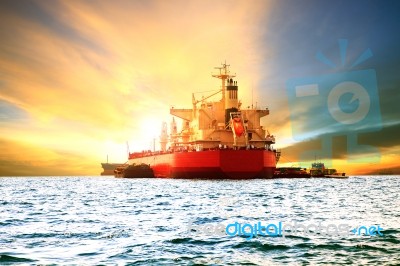 Commercial Container Ship Loading Goods In Sea Harbor Port Against Beautiful Sun Light Stock Photo