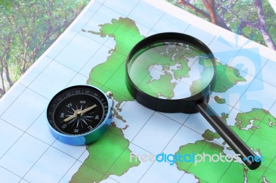 Compass And Magnifying Glass On World Map Stock Photo