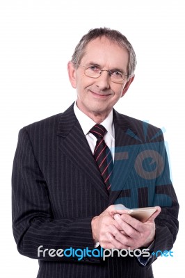 Confident Aged Businessperson Messaging Stock Photo