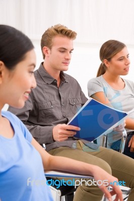 Confident Businessman Sitting With His Colleagues In Office Stock Photo