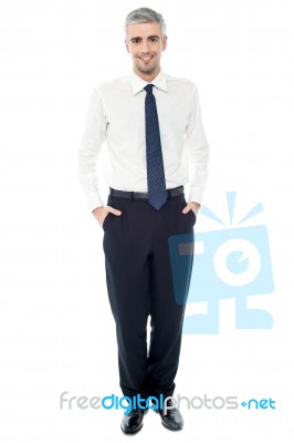 Confident Businessman With Hands In Pockets Stock Photo