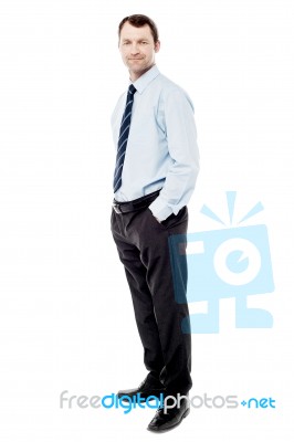 Confident Businessman With Hands In Pockets Stock Photo