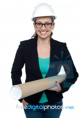 Confident Female Architect Carrying Blueprints Stock Photo