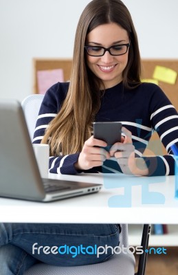 Confident Young Woman Working In Her Office With Mobile Phone Stock Photo