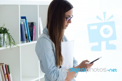 Confident Young Woman Working In Her Office With Mobile Phone Stock Photo