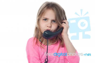 Confused Girl Speaking Over Phone Stock Photo