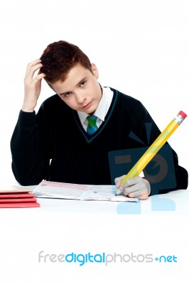 Confused Schoolboy Writing Stock Photo