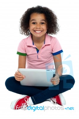 Cool Girl Kid Sitting On The Floor Holding Tablet Pc Stock Photo