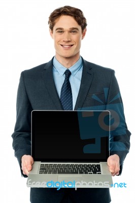 Corporate Executive Showing Laptop To Camera Stock Photo