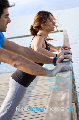 Couple Doing Push Ups Near The Sea Stock Photo