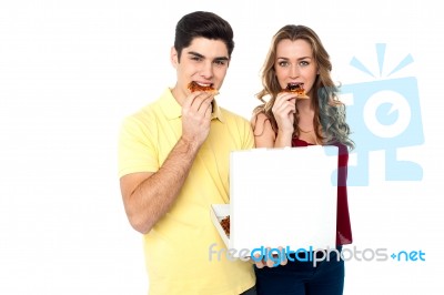 Couple Enjoying Pizza Slices Stock Photo