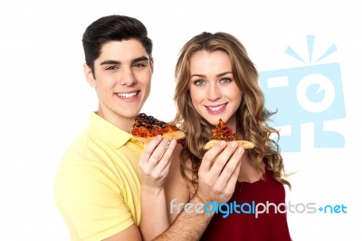 Couple Enjoying Pizza Slices Together Stock Photo