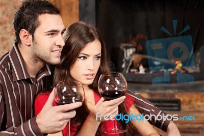 Couple Enjoying Wine Near Fireplace Stock Photo