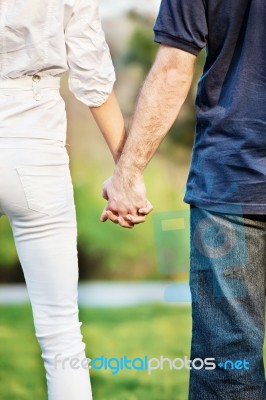 Couple Holding Hands In Park Stock Photo