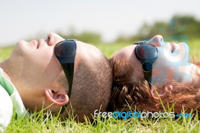 Couple Laying On Lawn Stock Photo