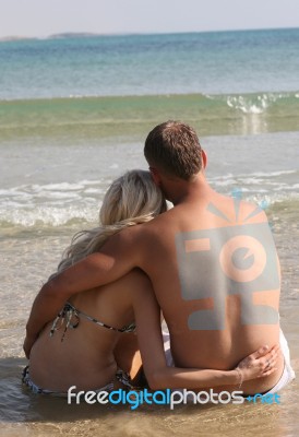 Couple Relaxing At Beach Stock Photo