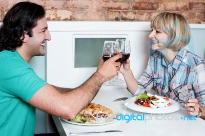 Couple Toasting Over A Restaurant Table Stock Photo