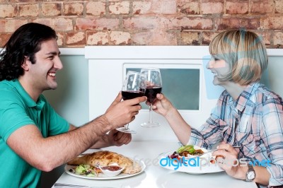 Couple Toasting Over A Restaurant Table Stock Photo