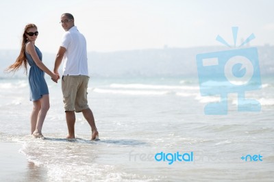 Couple Walking At Beach Stock Photo