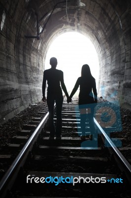 Couple Walking Together Through A Railway Tunnel Stock Photo