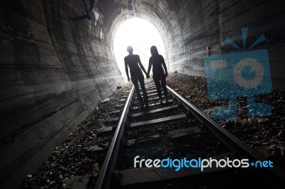 Couple Walking Together Through A Railway Tunnel Stock Photo