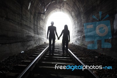 Couple Walking Together Through A Railway Tunnel Stock Photo