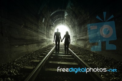 Couple Walking Together Through A Railway Tunnel Stock Photo