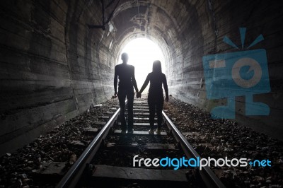 Couple Walking Together Through A Railway Tunnel Stock Photo