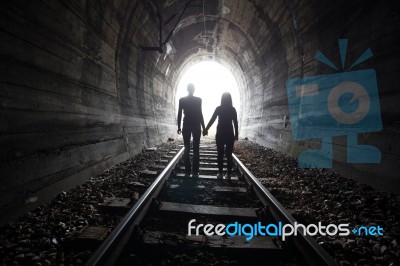 Couple Walking Together Through A Railway Tunnel Stock Photo