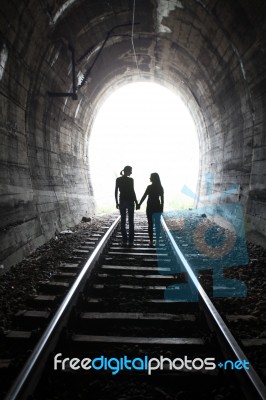 Couple Walking Together Through A Railway Tunnel Stock Photo