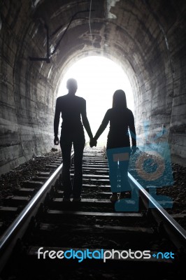 Couple Walking Together Through A Railway Tunnel Stock Photo