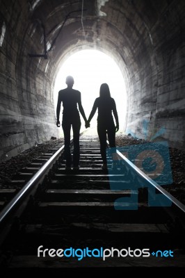 Couple Walking Together Through A Railway Tunnel Stock Photo