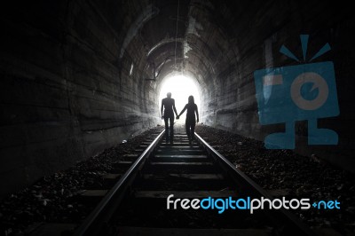 Couple Walking Together Through A Railway Tunnel Stock Photo